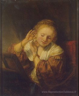 Jeune femme essayant des boucles d'oreilles