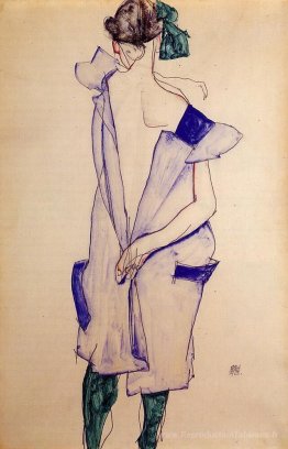 Fille debout dans une robe bleue et bas vert, vue arrière