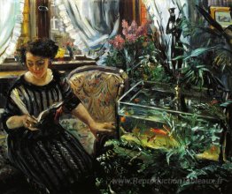 Femme par un réservoir de poisson rouge